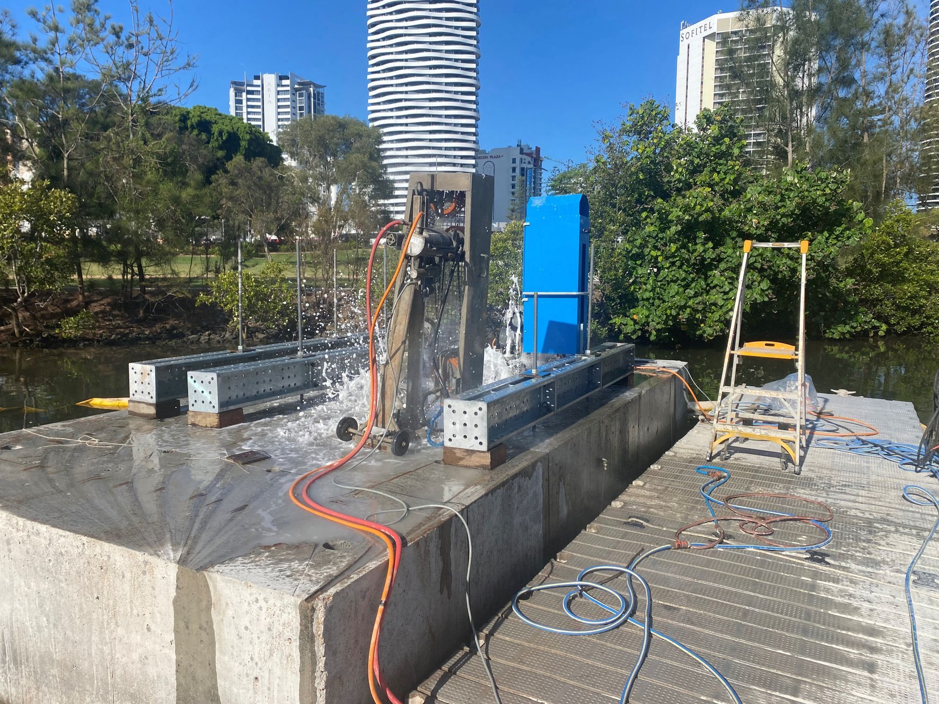 A person is cutting a concrete structure with a machine.