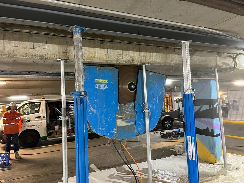A man is working on a machine in a parking garage.