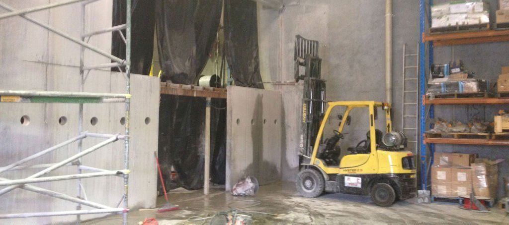 A yellow forklift is parked in a warehouse.