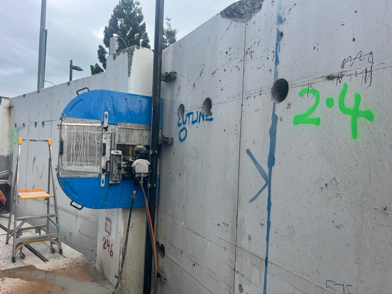 A machine is cutting holes in a concrete wall.