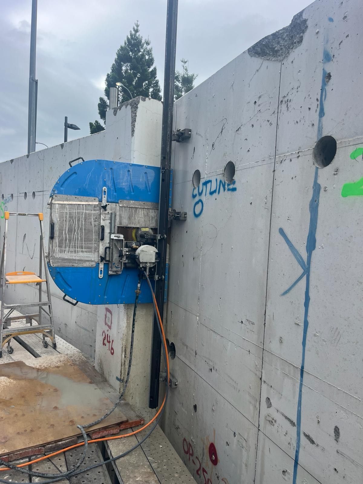 A machine is cutting a hole in a concrete wall.
