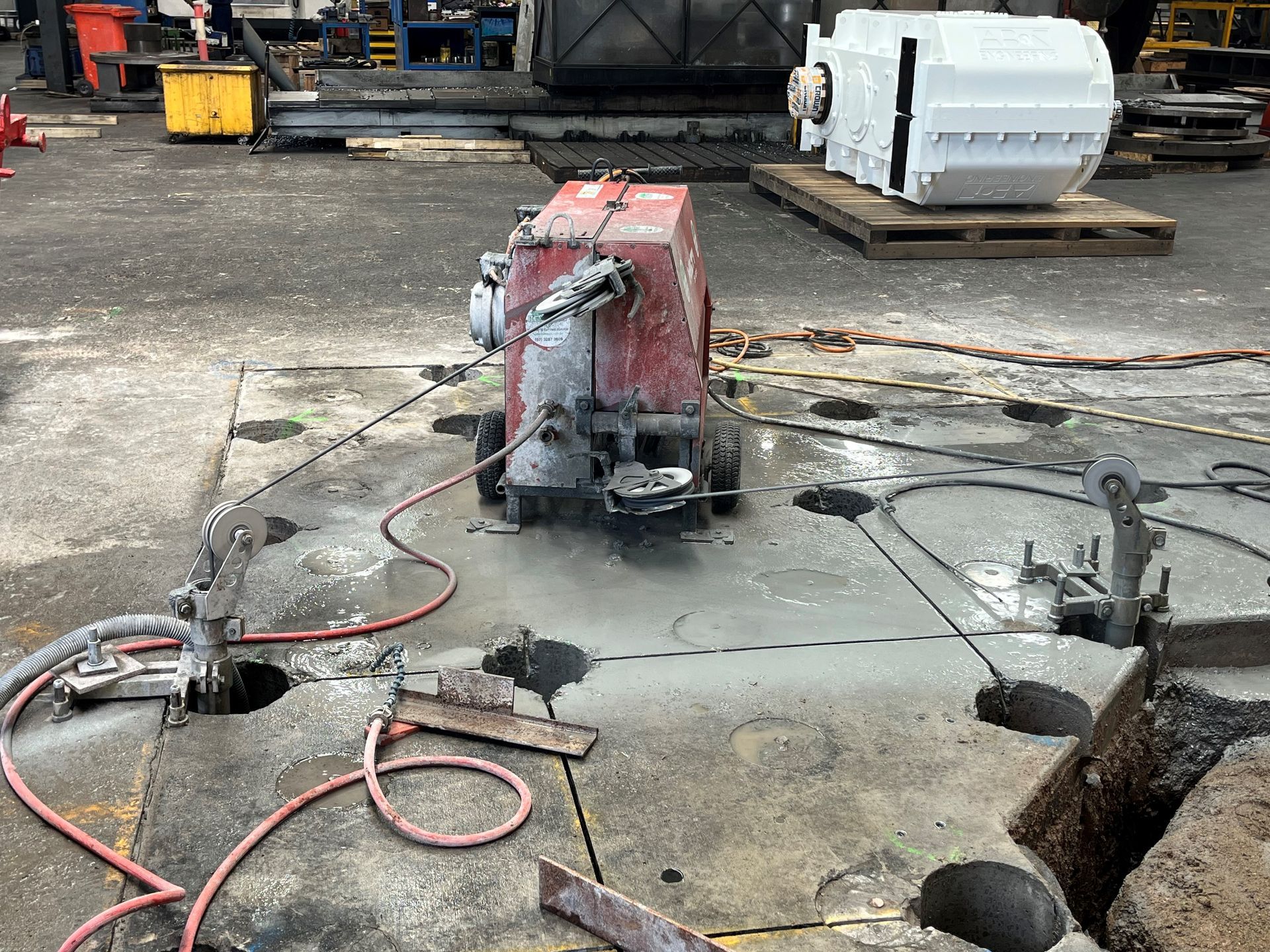 A machine is cutting concrete in a parking lot.