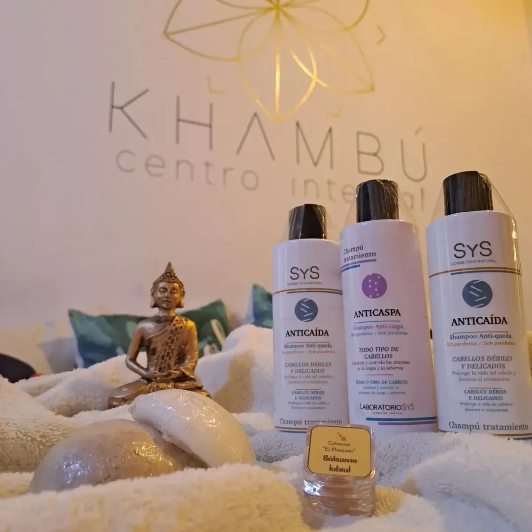 Tres botellas de cosméticos Sys están sobre una cama.