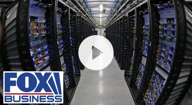 Rows of servers in a data center, lit with blue lights; Fox Business logo.