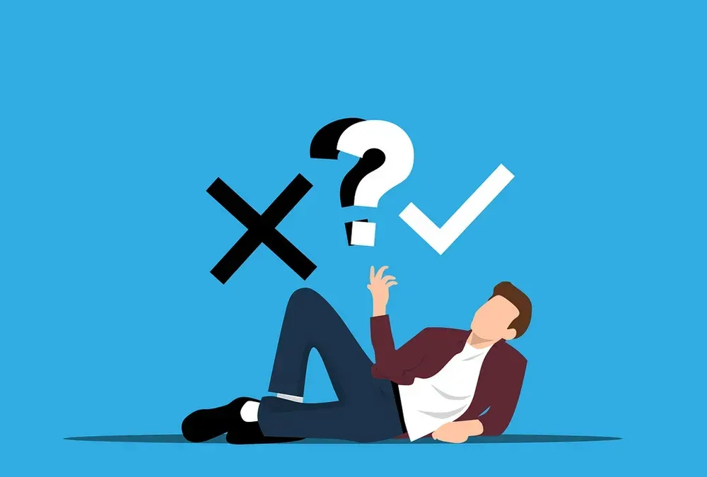 A man is laying on the floor with a question mark and a check mark above his head.