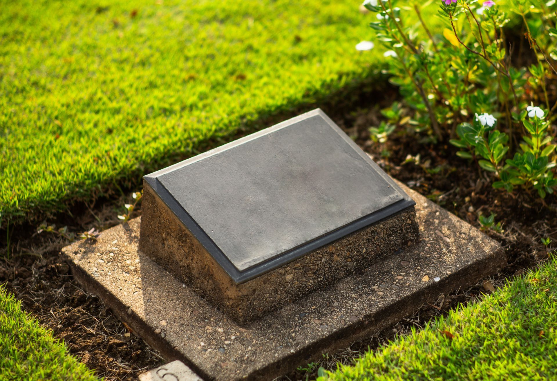 A bouquet of flowers is sitting on top of a grave in a cemetery.