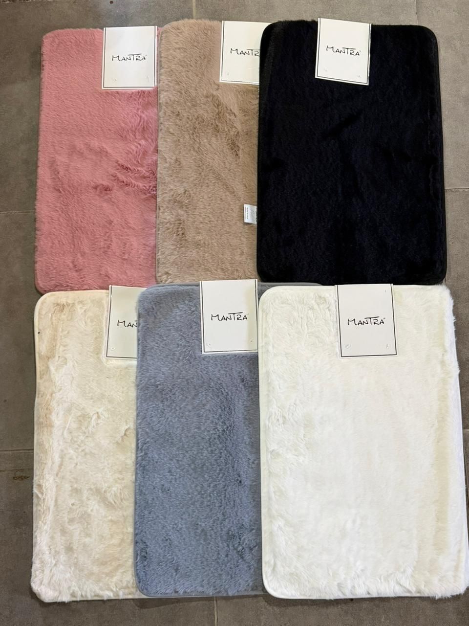 Seis muestras de tela texturizada en rosa, beige, negro, crema, gris y marfil dispuestas en una cuadrícula.