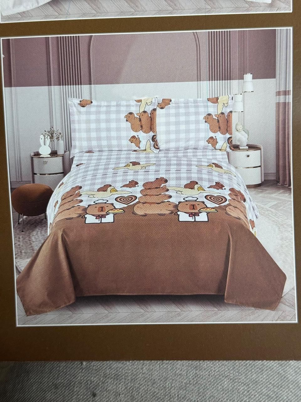 Ropa de cama con estampado de mariposas marrones y blancas sobre una cama bien hecha en un dormitorio luminoso.