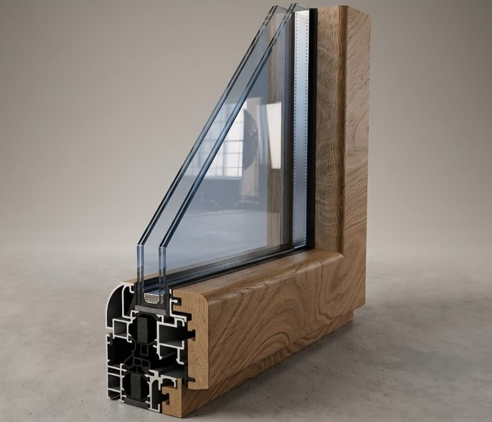 Primo piano di una sezione trasversale di un telaio di finestra con venature del legno e finiture interne nere su sfondo scuro.