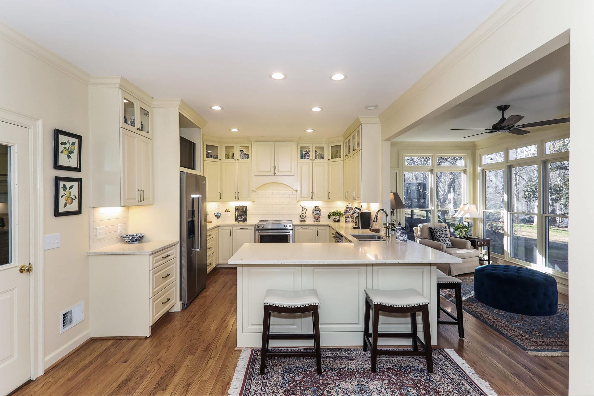 Bright remodeled kitchen open to living area with large windows and natural light