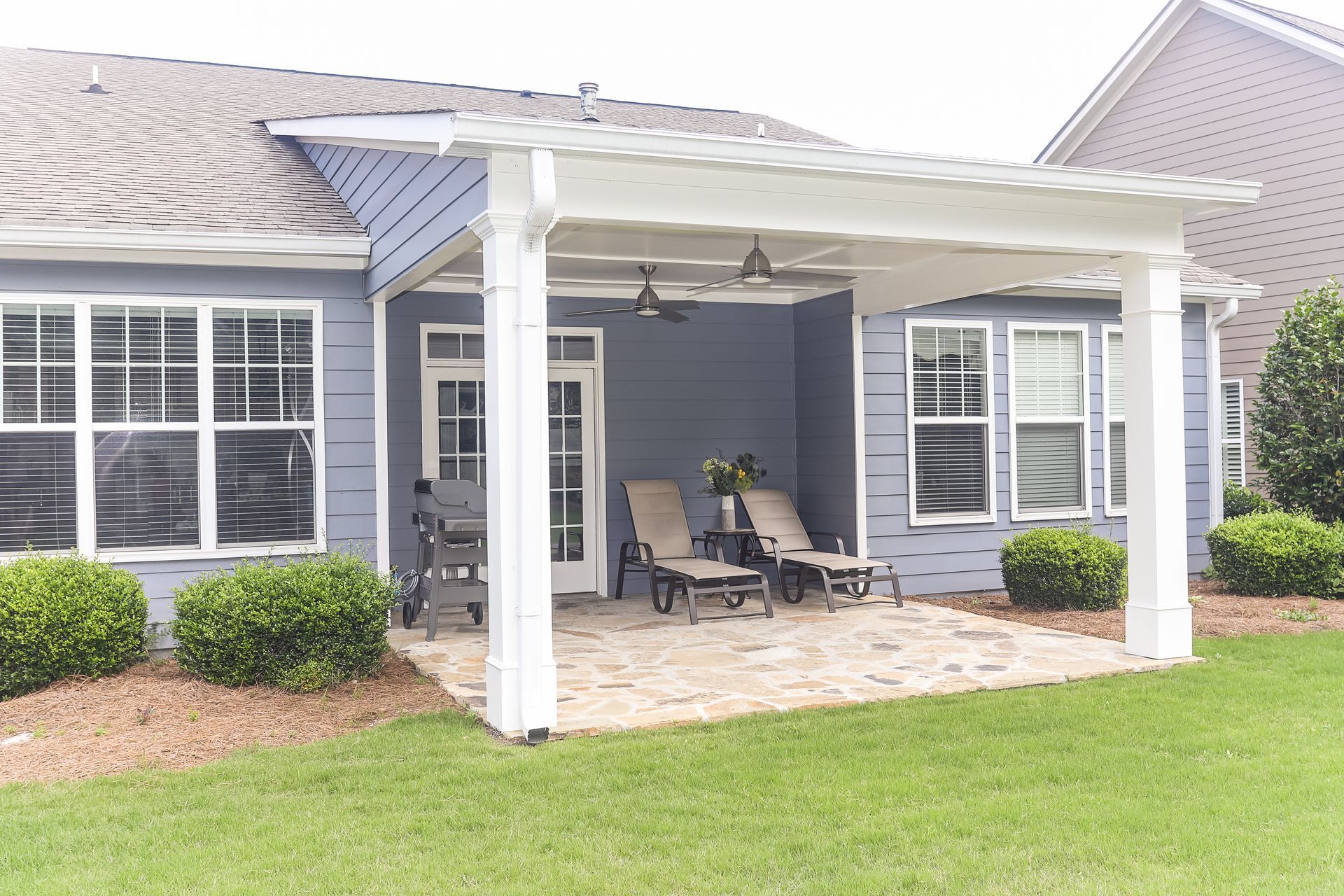 Covered back patio with outdoor seating by Tracy Tesmer Design and Remodeling