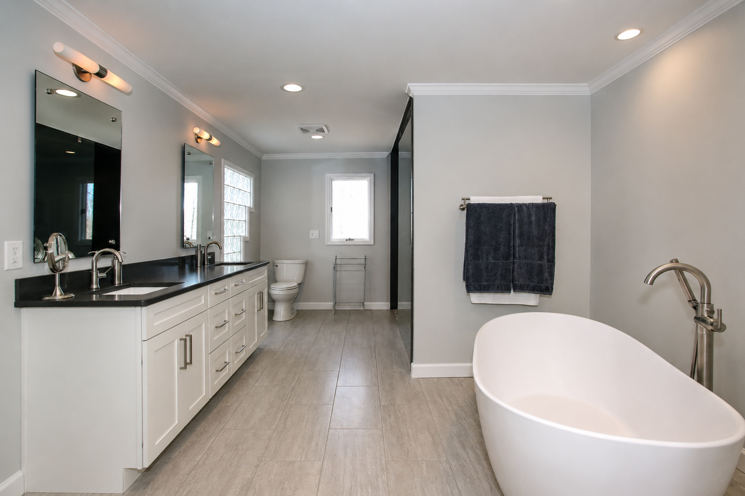 Spacious modern bathroom with double vanity, freestanding tub, and walk-in shower.