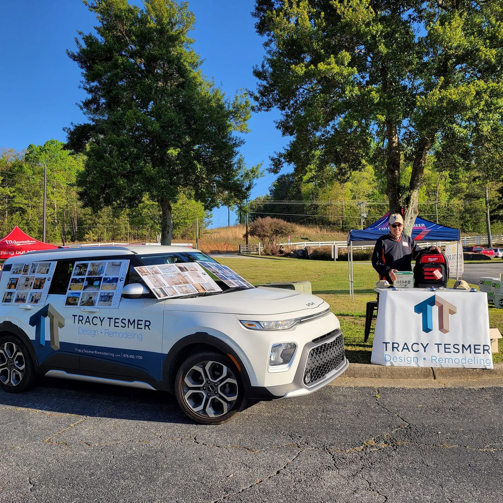 Tracy Fisher campaign car parked by a roadside banner at an outdoor event, with a person standing beside it