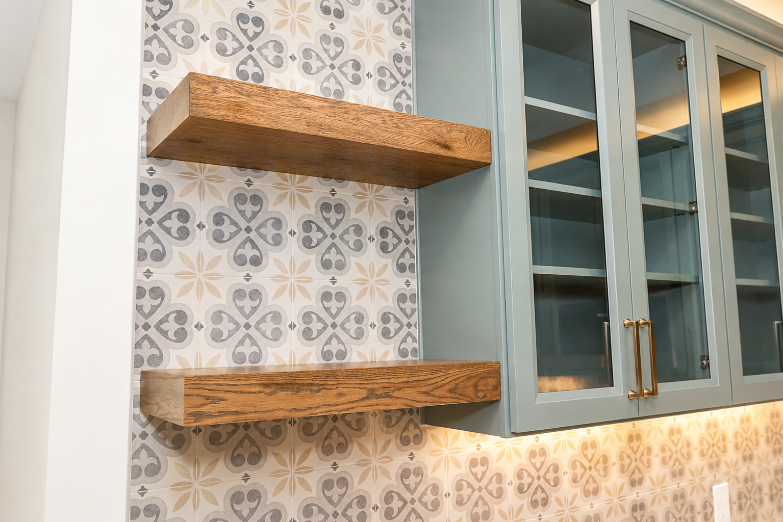 Kitchen shelves and cabinets with patterned tile backsplash and soft blue framing
