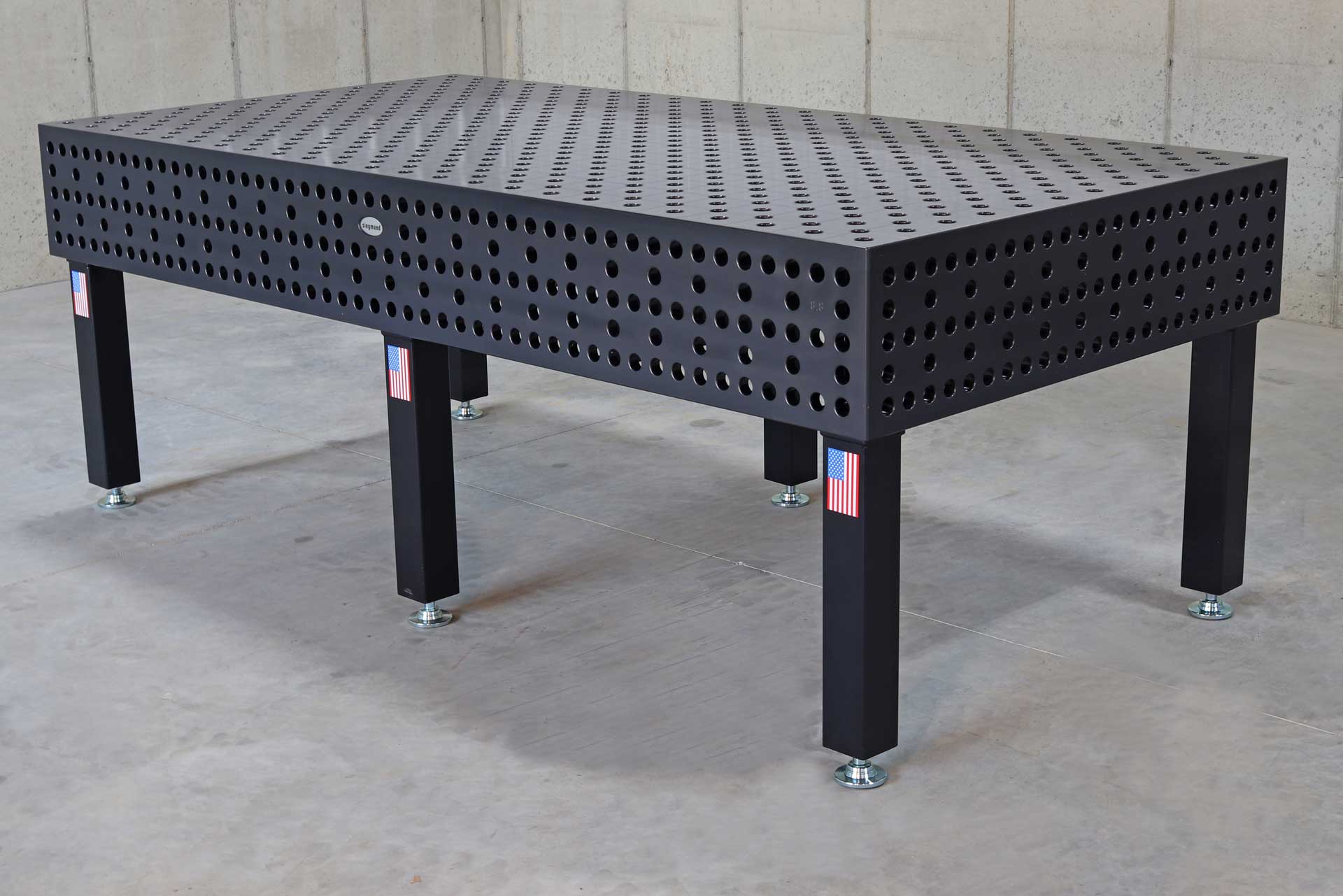Siegmund Professional Extreme PLUS A black table with holes in it is sitting on a concrete floor