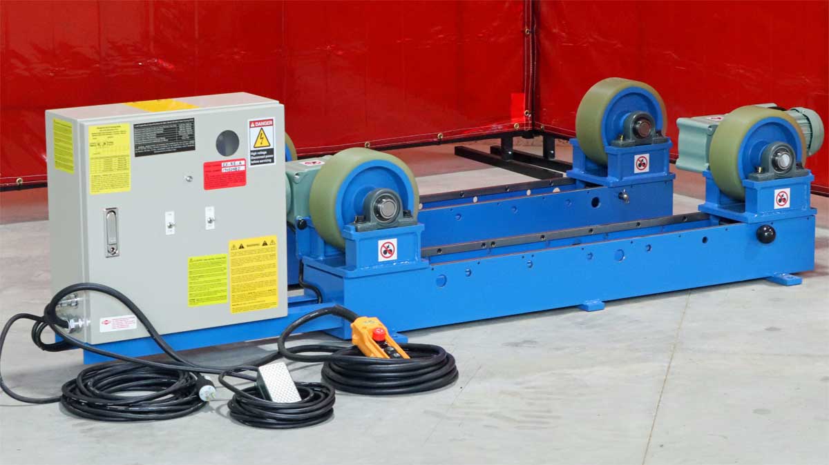 A blue machine with green wheels is sitting on a concrete floor.