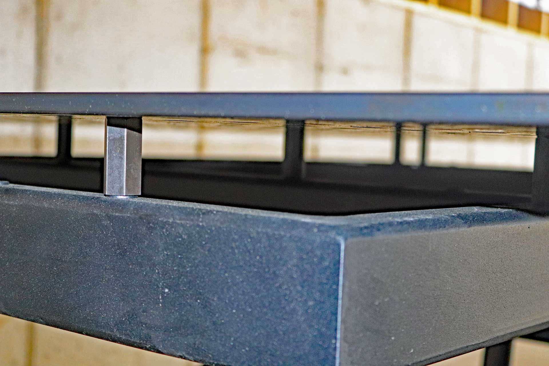 Siegmund Lifting Table A close up of a metal table with a concrete base.