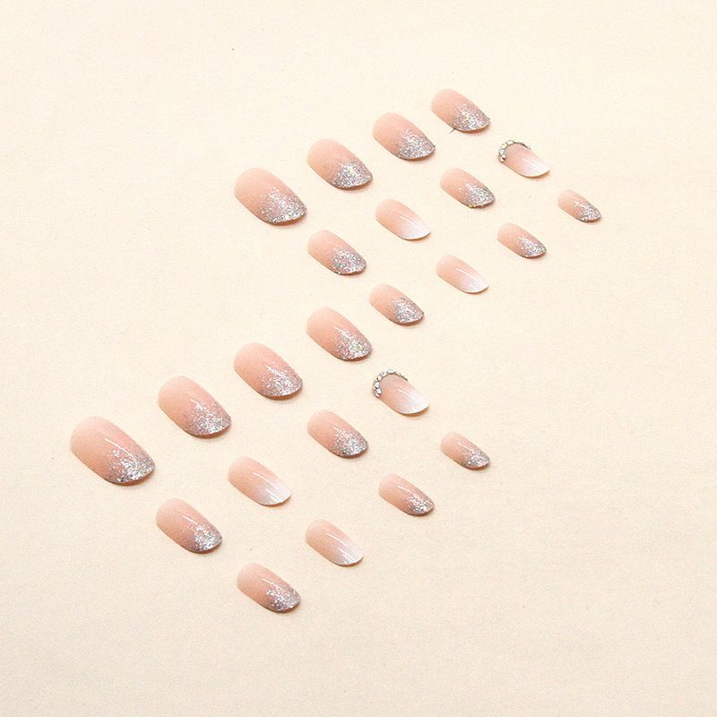 A close up of a woman 's nails with rhinestones on them.