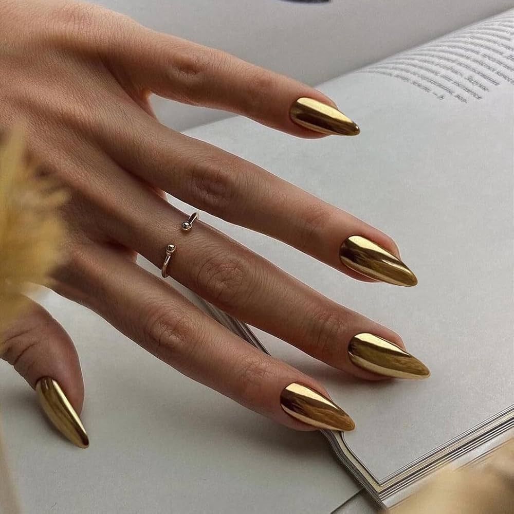 A close up of a woman 's hand with gold nails