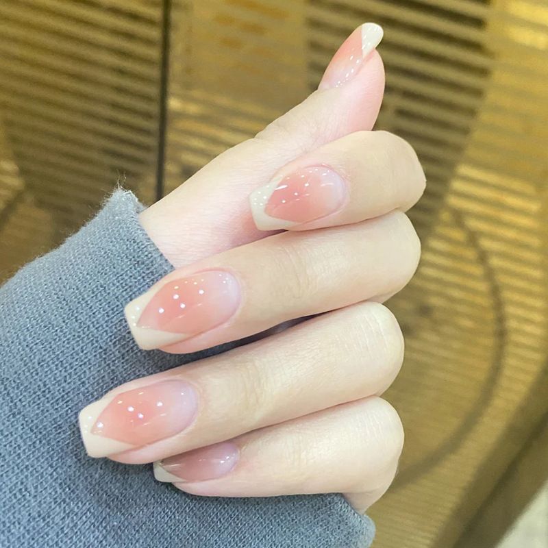 A close up of a person 's nails with a french manicure.