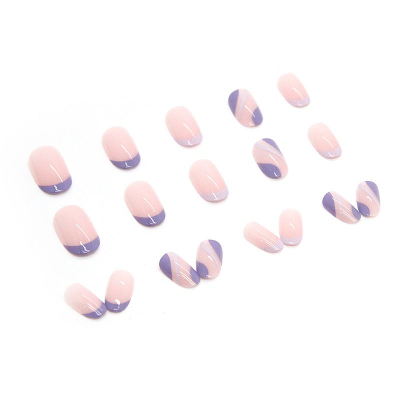 A close up of a woman 's hand with purple and pink nails.