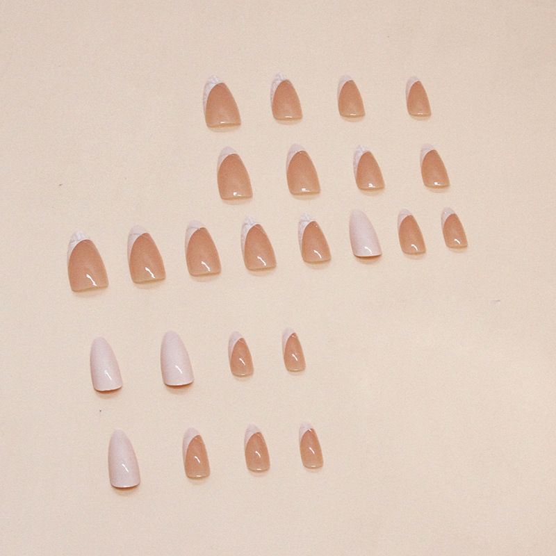 A close up of a woman 's nails with a gold ring