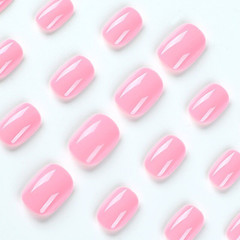 A close up of a woman 's hand with pink nails.