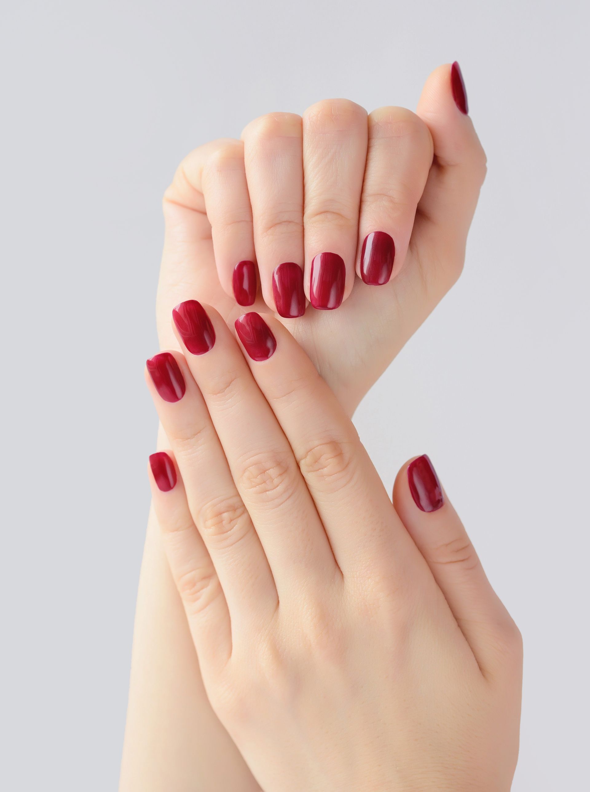 A close up of a woman 's hands with red nails