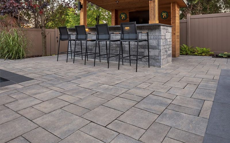 Un patio avec un bar et des chaises dessus.