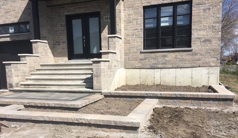 Une maison en briques avec des escaliers menant à la porte d'entrée