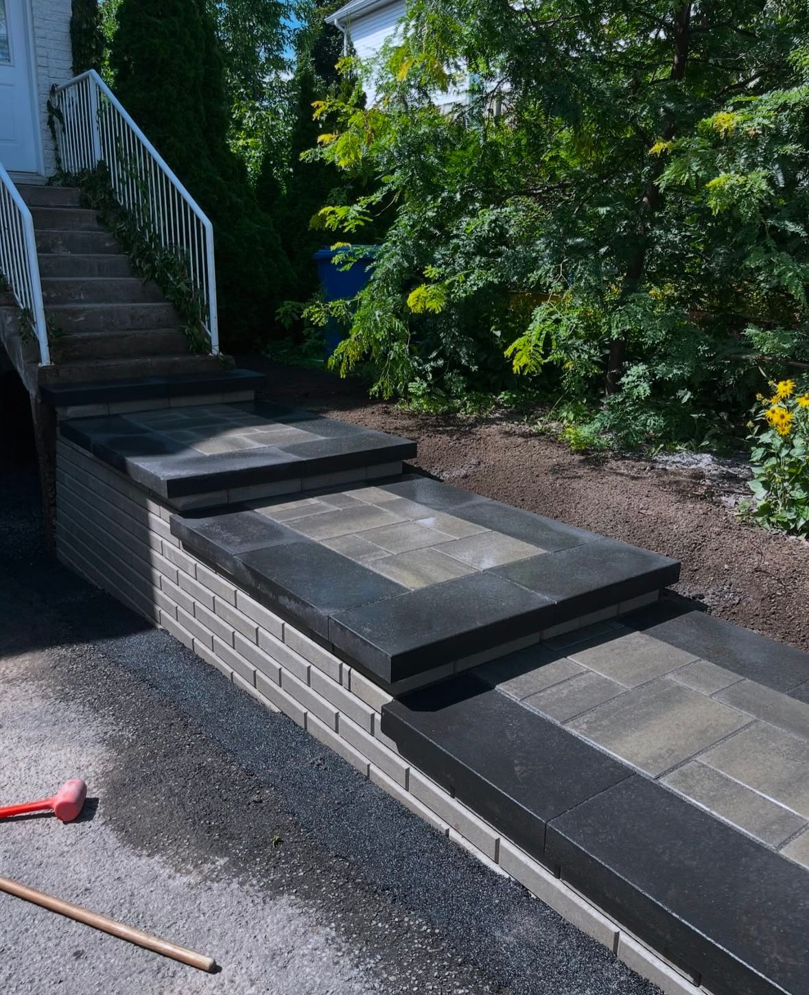 Une allée en briques avec des escaliers menant à une maison