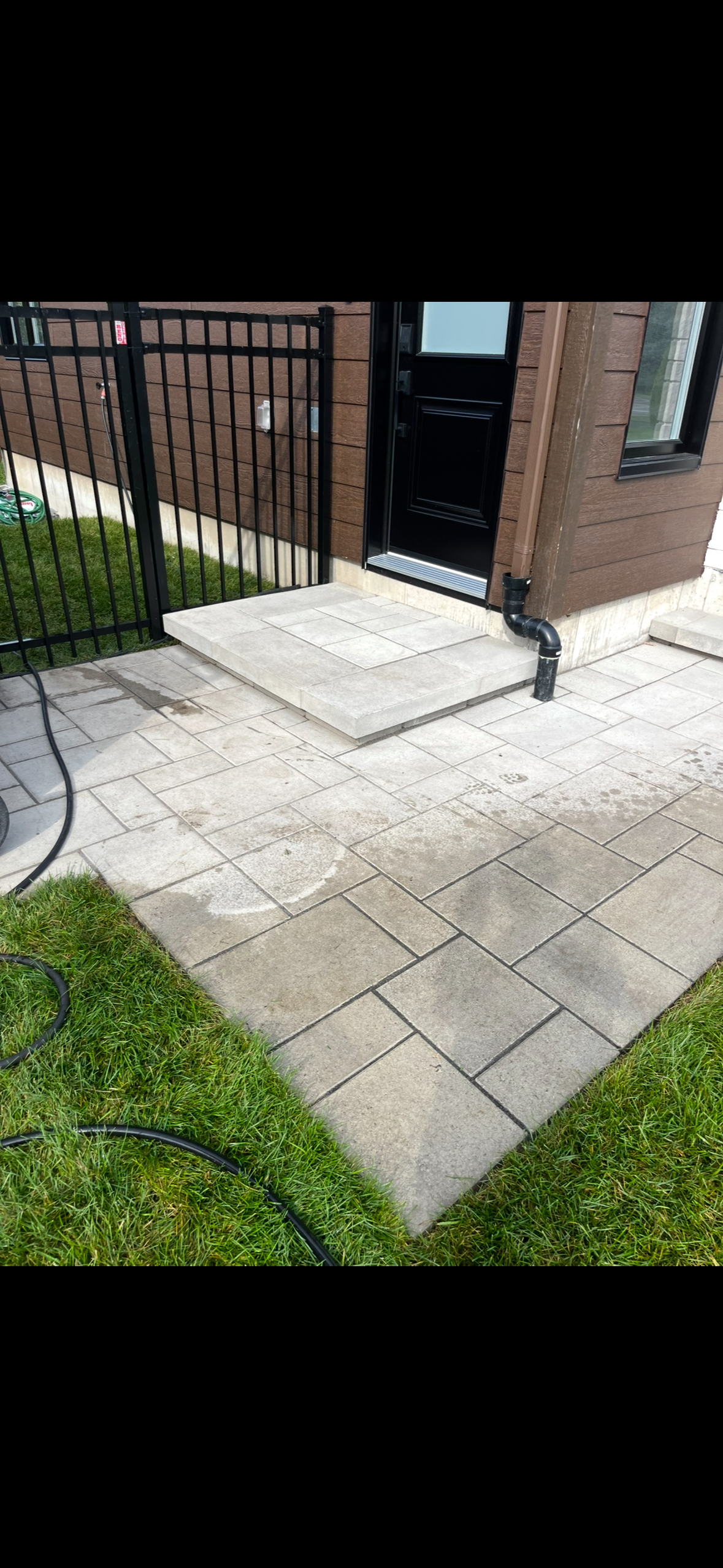 Un patio avec une clôture et une porte en arrière-plan.