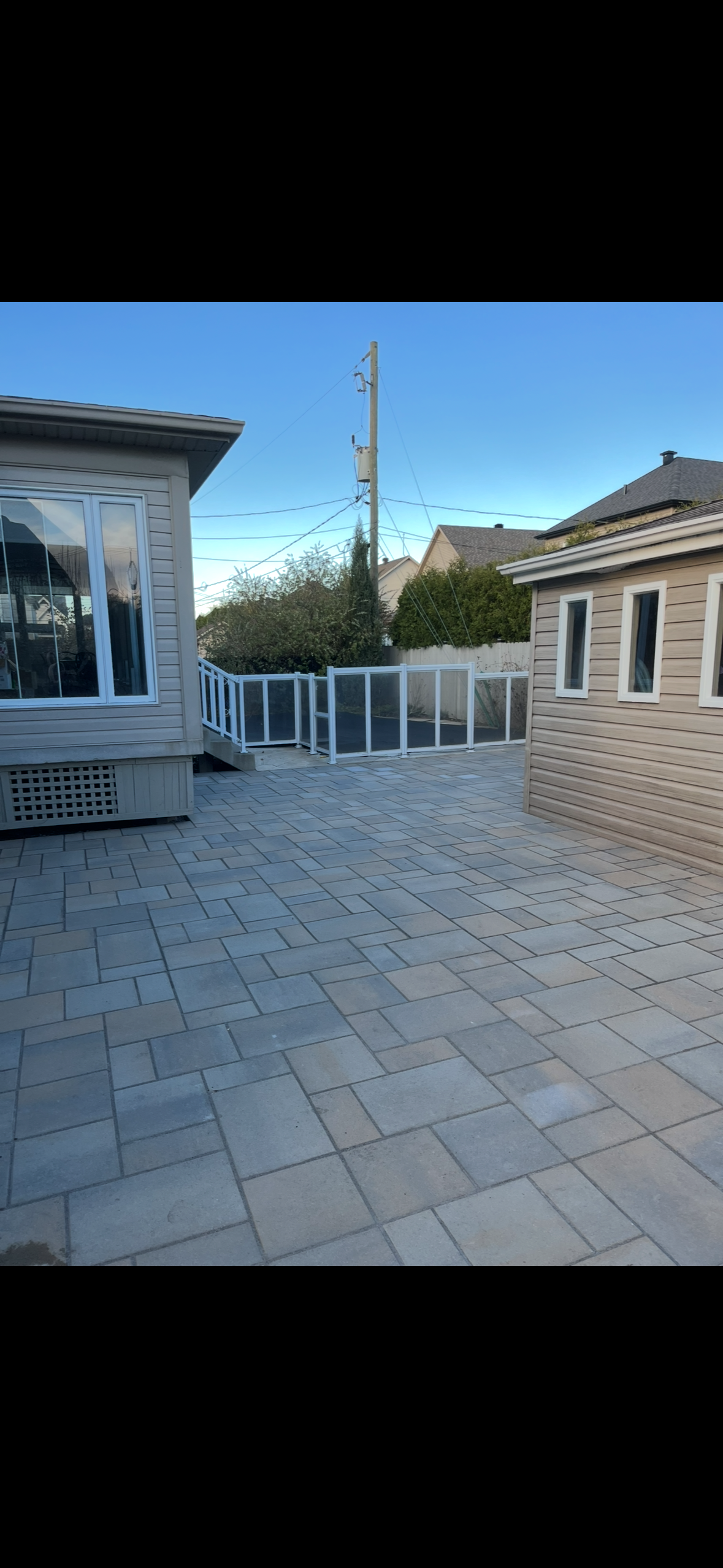 Une maison en briques avec une clôture et un patio devant.