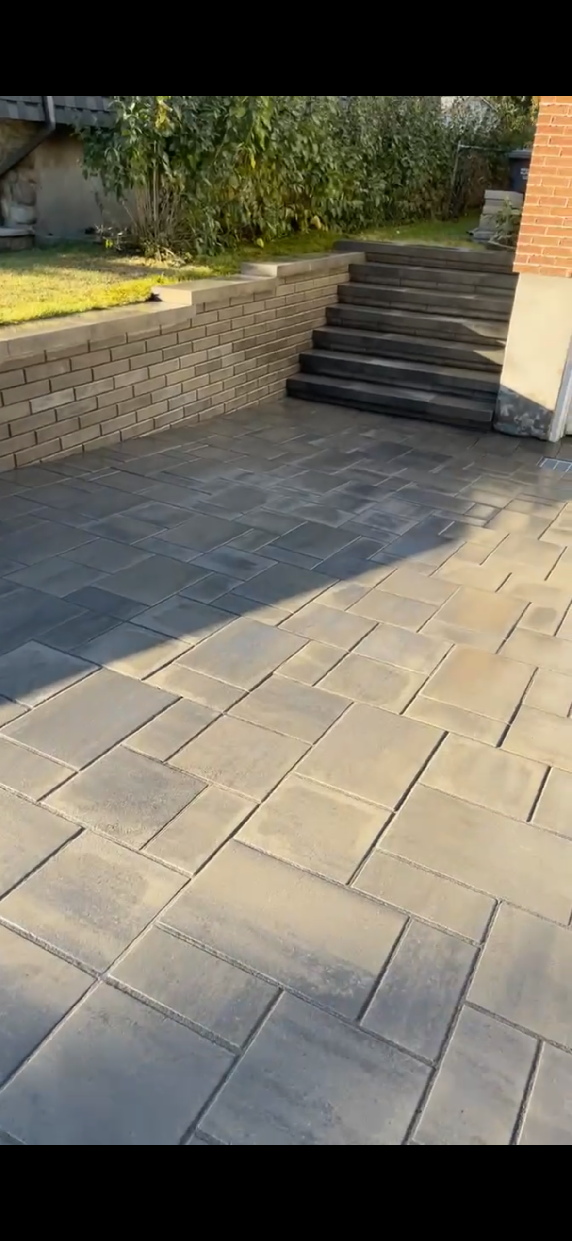 Un patio avec des escaliers et un mur en arrière-plan.