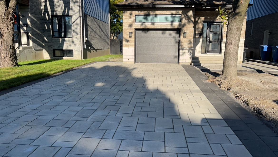 Une allée en briques menant à une maison avec un garage.