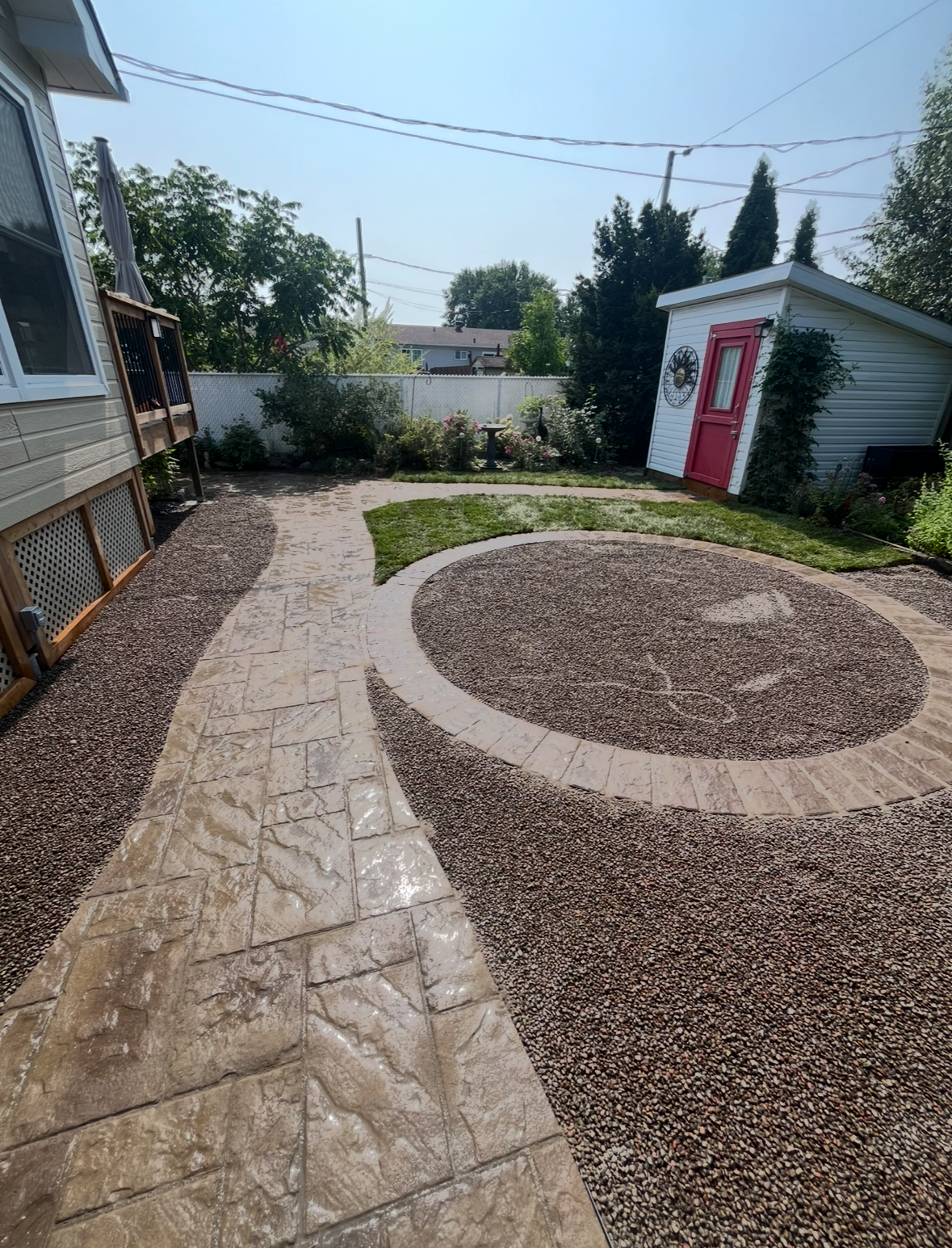 Un patio avec un cercle au milieu devant une maison.