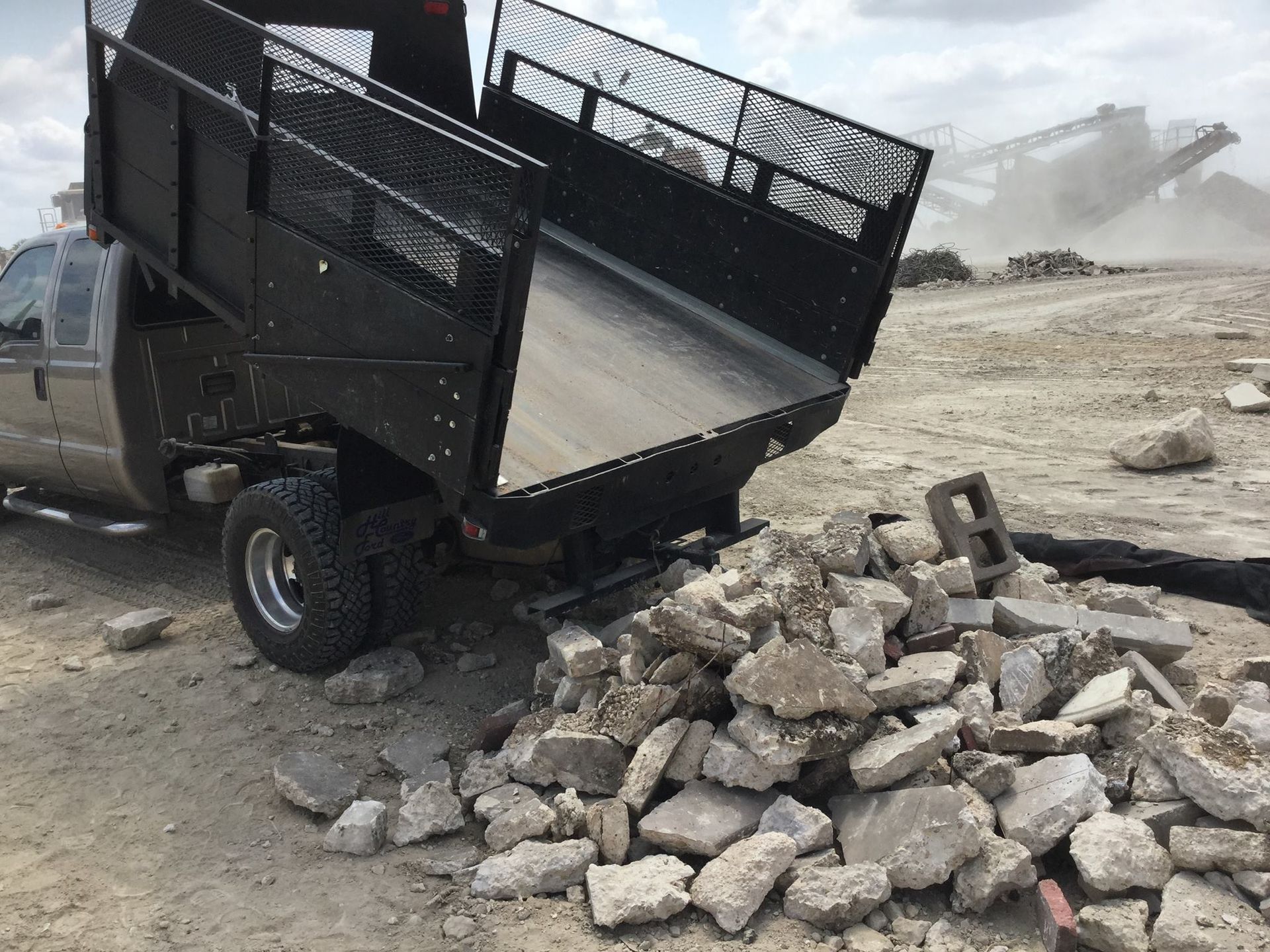 A truck is sitting on top of a pile of rocks.