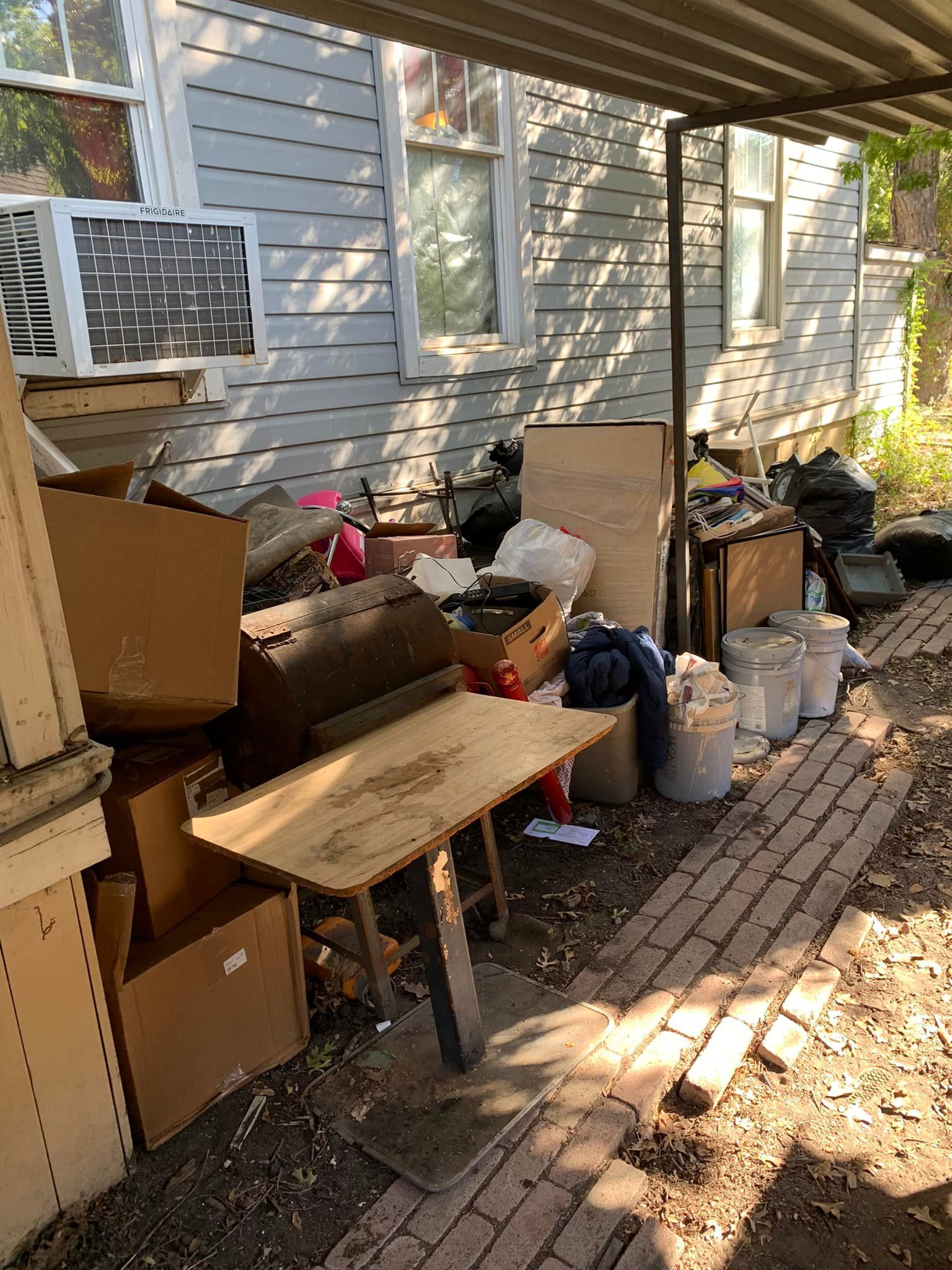 There is a lot of trash in the backyard of a house.
