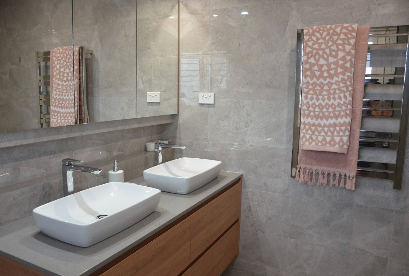 A bathroom with two sinks and a towel rack