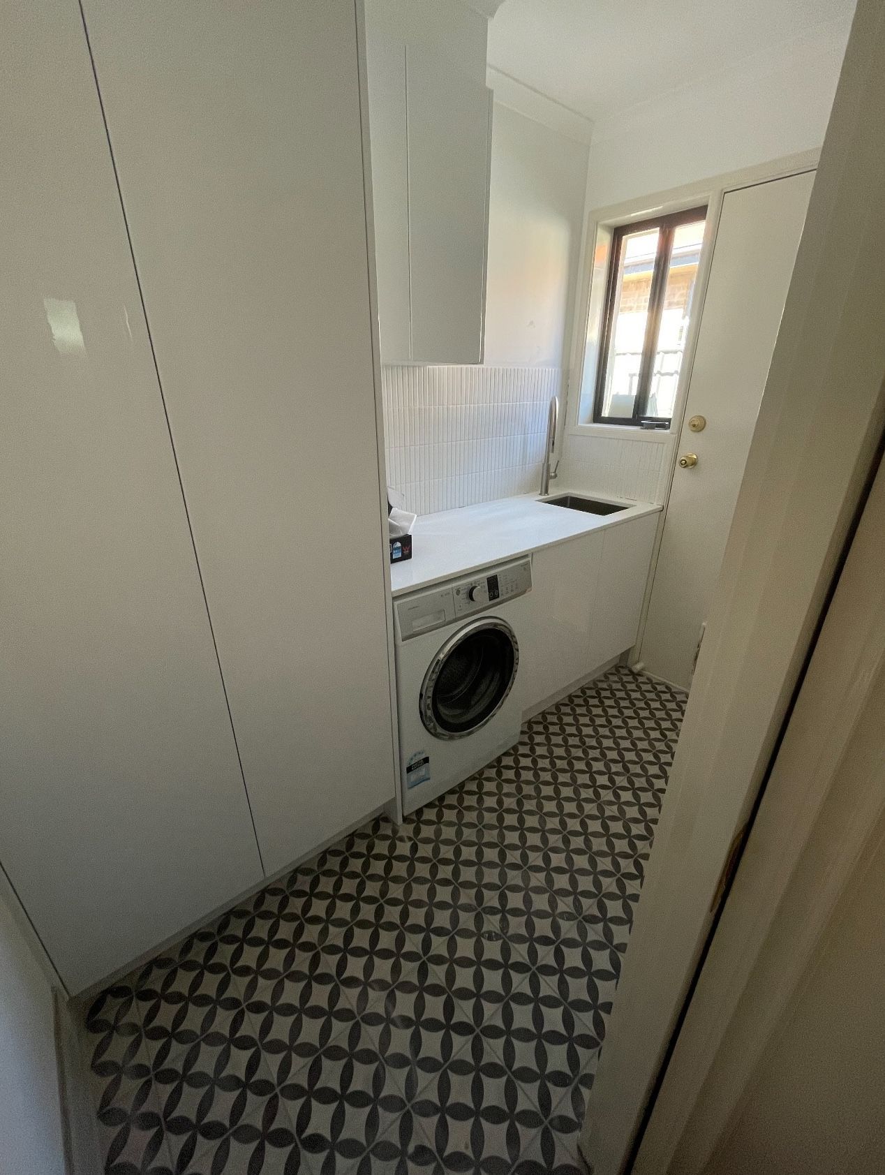A laundry room with a washer and dryer and a window.