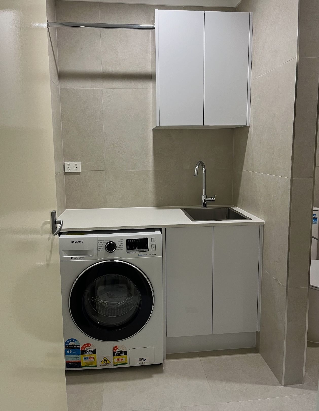 A laundry room with a washer and dryer and a sink