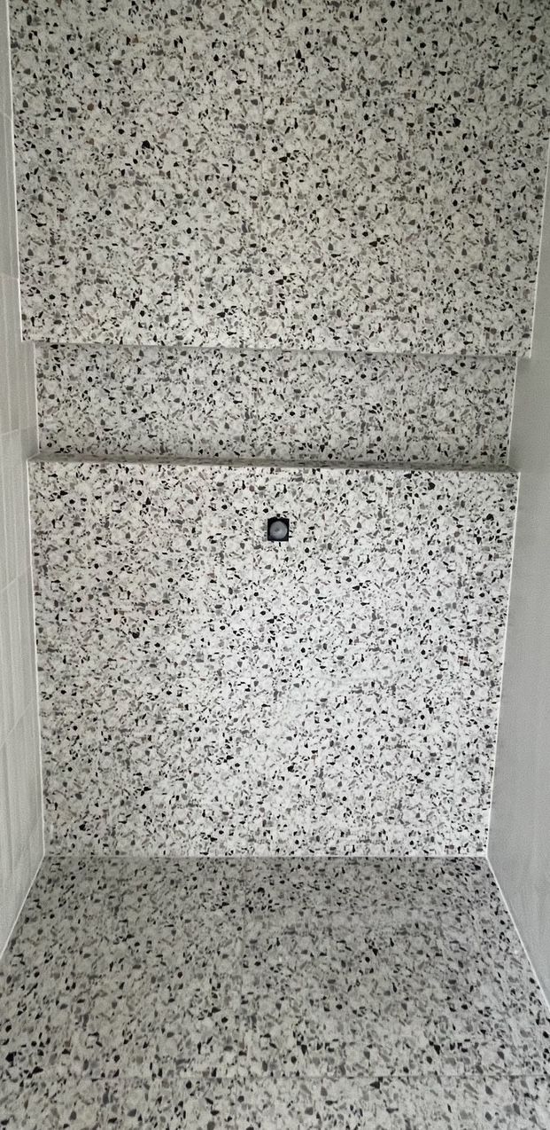 A close up of a white tile floor in a bathroom.