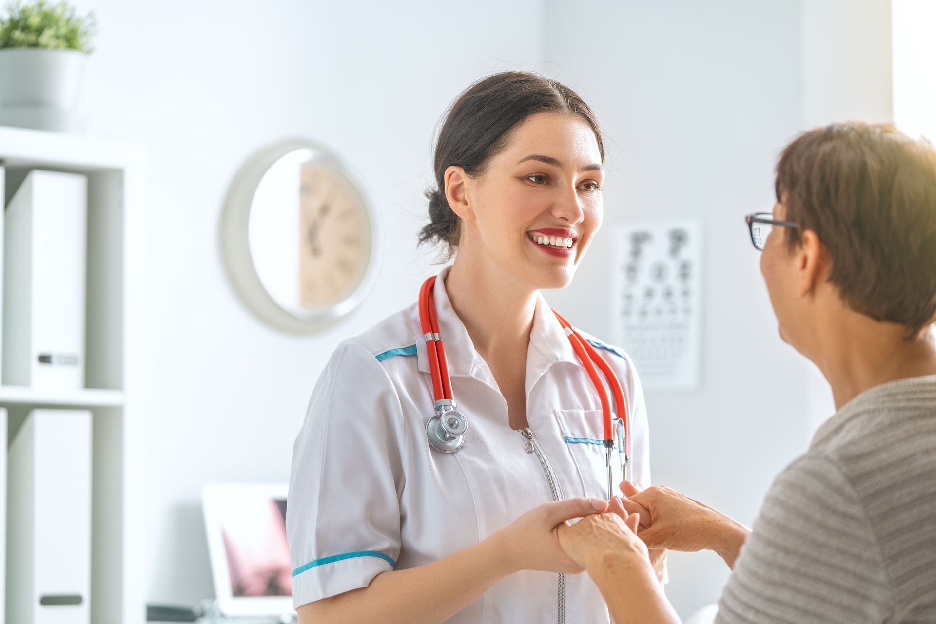 A female doctor is shaking hands with a patient in a hospital.