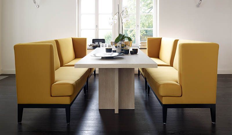 Ein Esszimmer mit gelben Bänken und einem Tisch