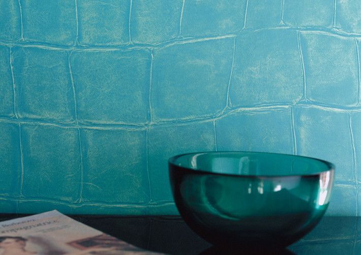 Eine blaue Schüssel steht auf einem Tisch vor einer blauen Wand.