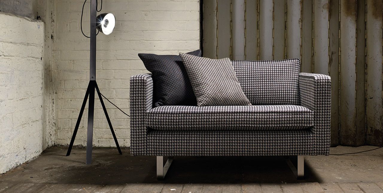Eine schwarz-weiße Couch in einem Zimmer neben einer Lampe