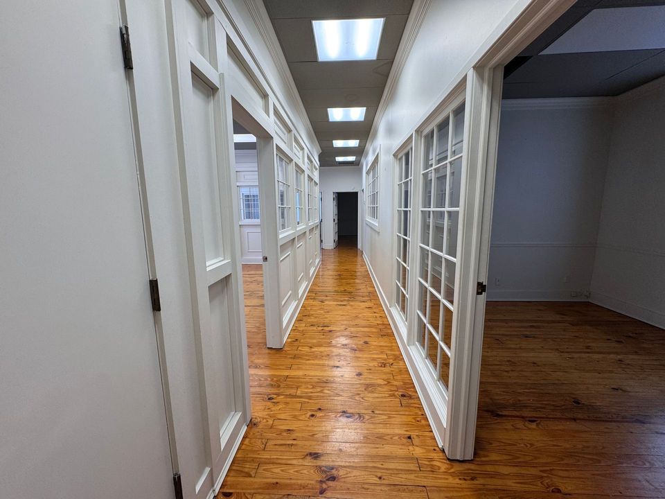 First floor hallway with glass French doors and hardwood floors