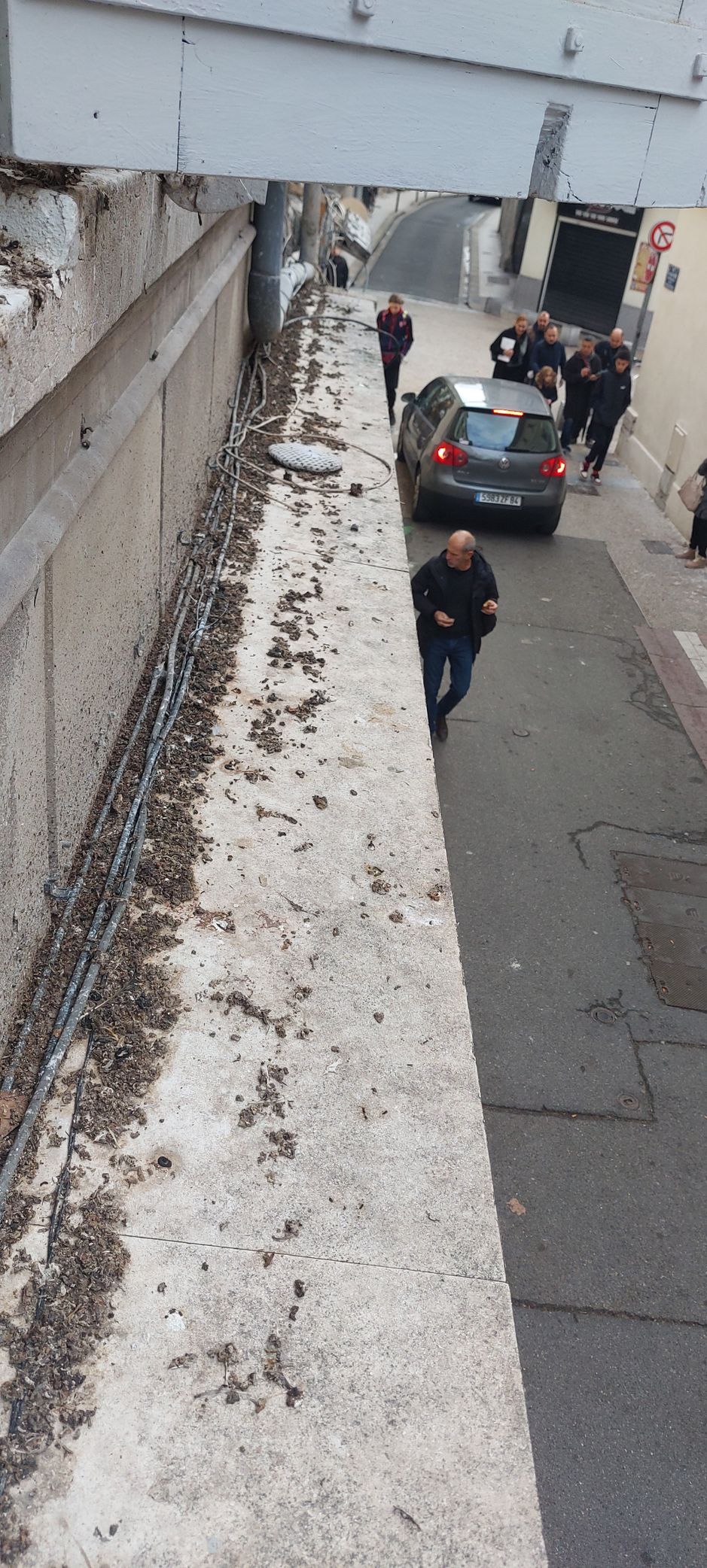 Un homme marche dans une rue à côté d'un mur recouvert de neige.