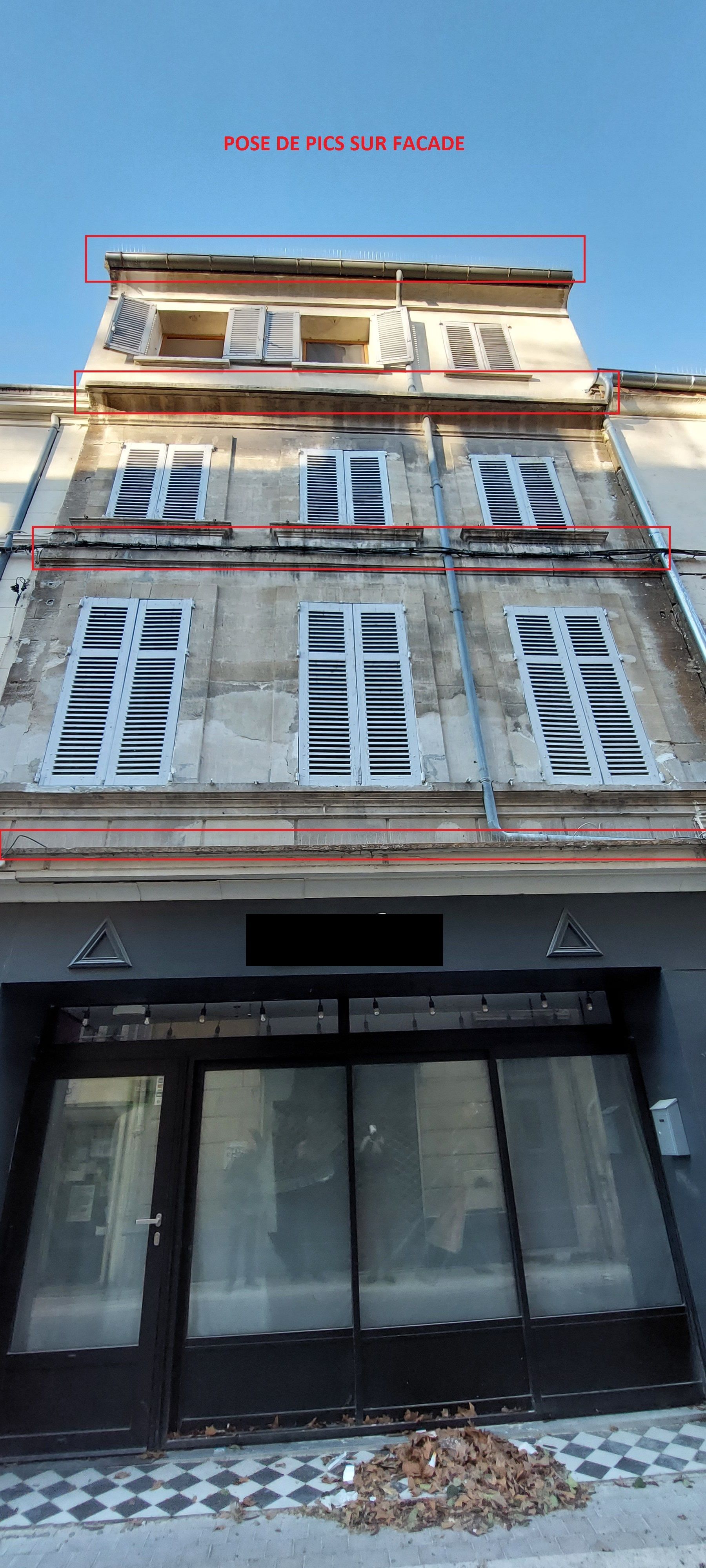 Un grand bâtiment avec beaucoup de fenêtres et un ciel bleu en arrière-plan.