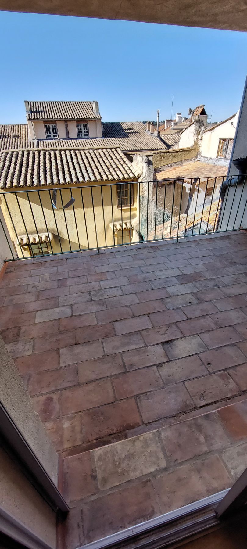 Une vue d'une ville depuis un balcon avec un sol en brique.